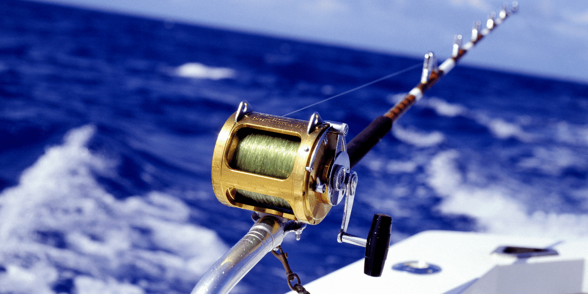 A deep sea fishing rod and reel on the back of a boat